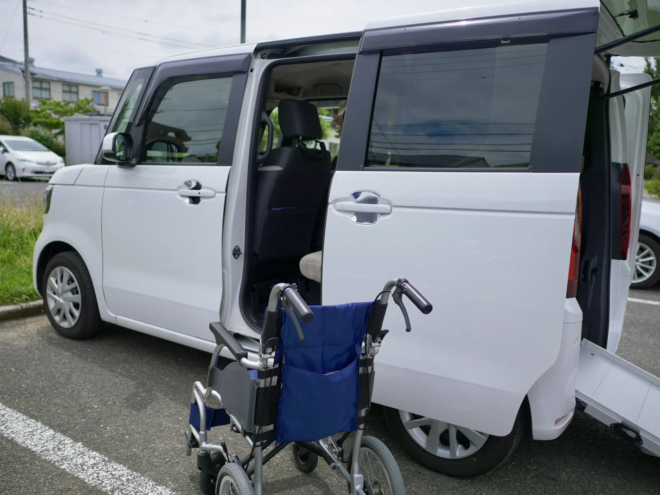 側面スライドドアを開いた介護タクシーと車いす